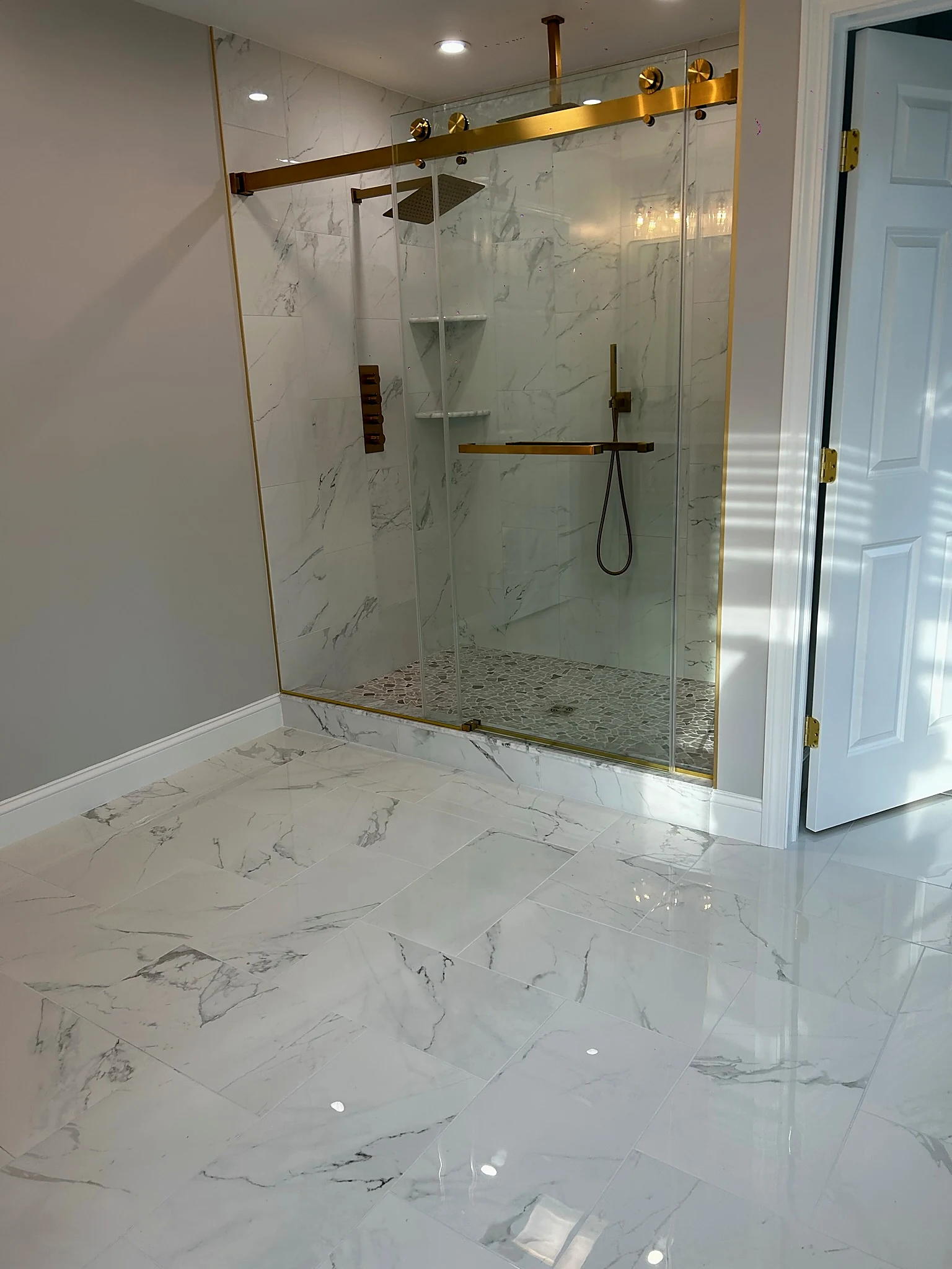 Marble bathroom with glass shower by Adael Construction