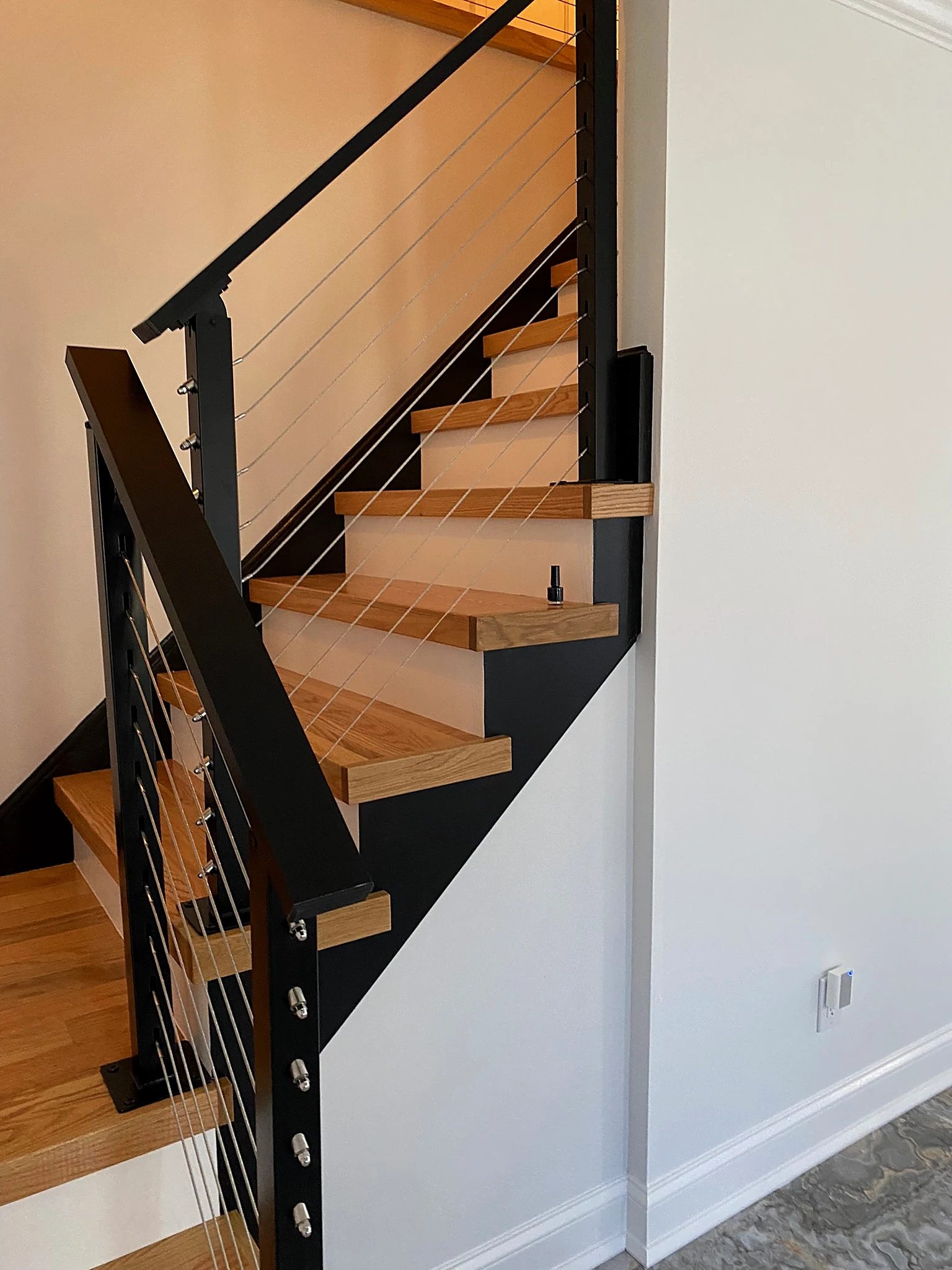 Oak staircase with cable railing by Adael Construction